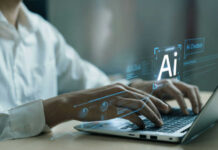 Person typing on laptop with AI hologram display