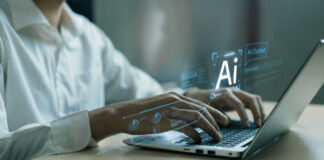 Person typing on laptop with AI hologram display