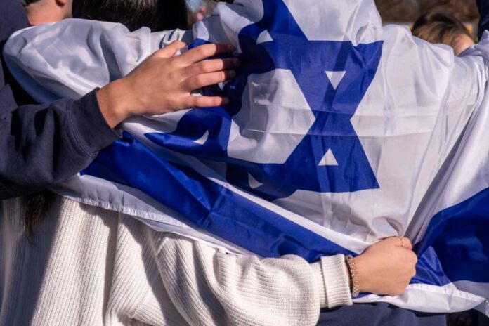 People holding an Israeli flag together, showcasing unity and cultural pride