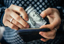 TRUMP’S Tax Changes Deliver Unseen Refund Bonanza Hands placing hundred dollar bills in wallet