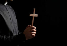 priest holding a cross