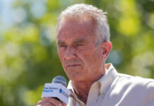 Man speaking into microphone at outdoor event