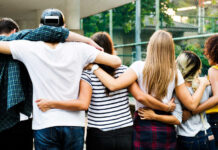 A group of friends standing together with arms around each other
