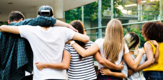 A group of friends standing together with arms around each other