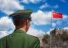 Massive Chengdu Expansion – China’s Fighter Fleet SOARS Soldier in a green military uniform facing the Great Wall of China with the Chinese flag in the background