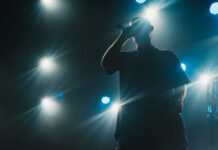 Digital Heist: AI-Driven Scam Hits Music Industry Silhouette of a musician performing on stage with bright lights