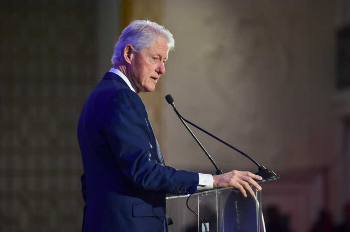 shutterstock_1621203043.jpg A man in a suit speaking at a podium with a microphone