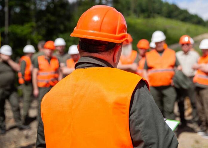 Group of workers in safety gear attending a briefing