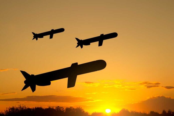 shutterstock_2413429857.jpg Silhouettes of missiles flying against a sunset backdrop