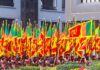 Group of individuals in traditional attire holding flags during a parade