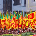 Group of individuals in traditional attire holding flags during a parade