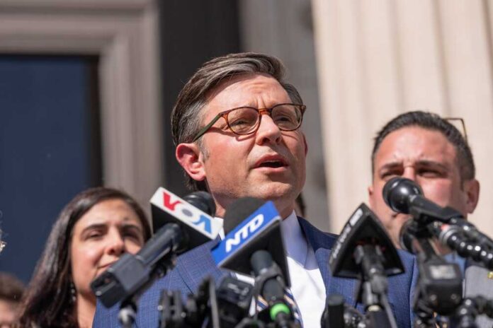 A man speaking at a press conference surrounded by microphones