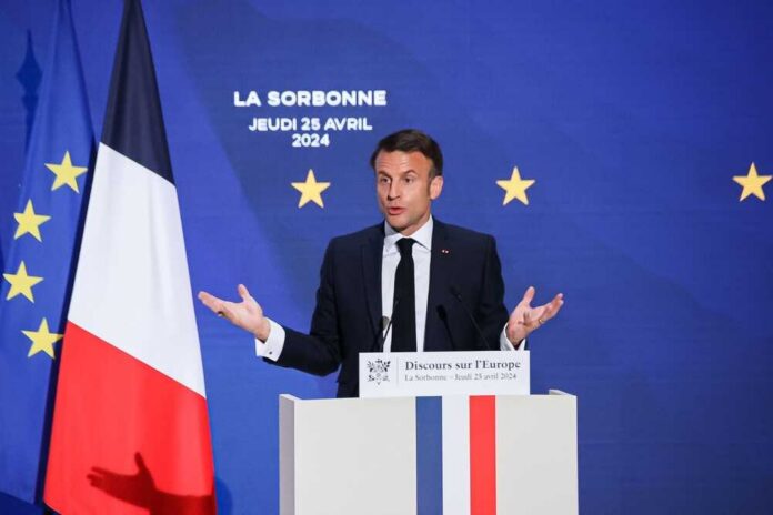 shutterstock_2454120107.jpg Emmanuel Macron delivering a speech at La Sorbonne with flags in the background