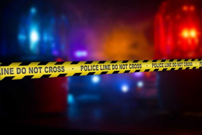 shutterstock_2562307639.jpg Police crime scene tape with emergency lights in the background