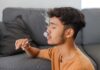 E-Cigarettes CRUSH Traditional Quit Aids Young man sitting on a couch, vaping with smoke around him