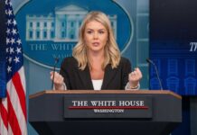 A government official speaking at a podium during a press briefing