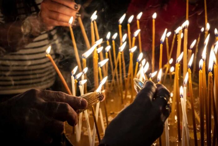 Hands lighting candles during a religious ceremony