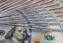 A close-up view of a stack of hundred dollar bills arranged neatly
