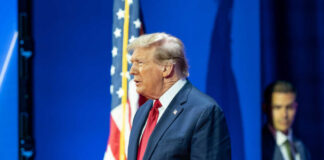 Man in suit with American flag background