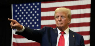 Man pointing with American flag in background