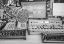 Microphone in radio studio with mixing equipment