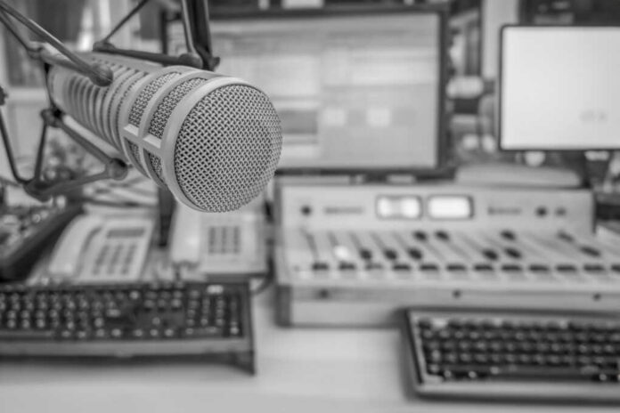 Microphone in radio studio with mixing equipment