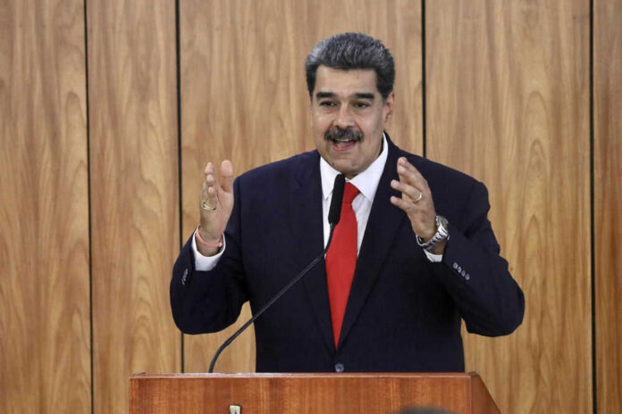 nicols-maduro659264888 Man speaking at podium with wood panel background