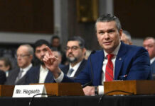 Democrats TARGET Defense Secretary in Bold Impeachment Move Man speaking at a panel discussion meeting