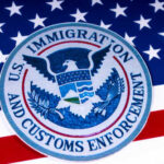 Seal of U.S. Immigration and Customs Enforcement on an American flag background