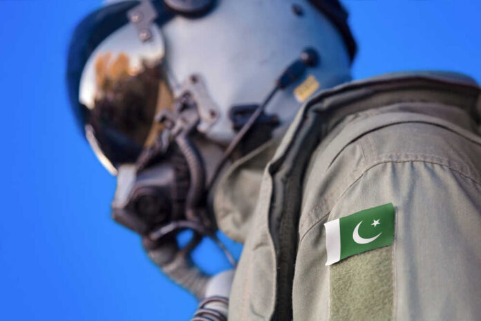 Close-up of a military pilot wearing a helmet and a uniform with a Pakistan flag patch