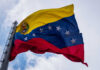 Venezuelan flag waving against a cloudy sky