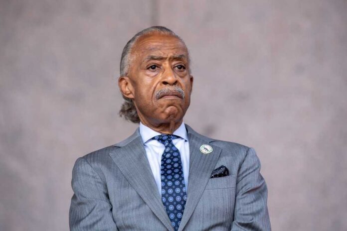 A serious-looking man in formal attire at a speaking event