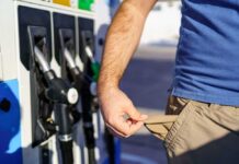 Person showing empty pockets at a gas station