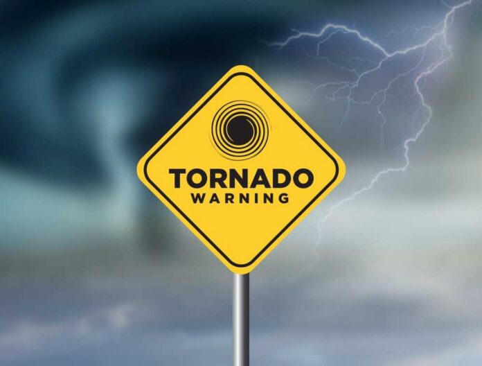 A yellow tornado warning sign against a stormy background