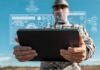 AI Arms Race: Risking Global Catastrophe A soldier holding a tablet displaying digital data overlays