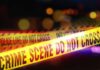 Feds Slammed: Catch-and-Release Ends in Horror Yellow police tape marking a crime scene with blurred lights in the background