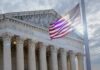 The Supreme Court building with an American flag waving in front