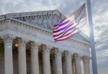 The Supreme Court building with an American flag waving in front