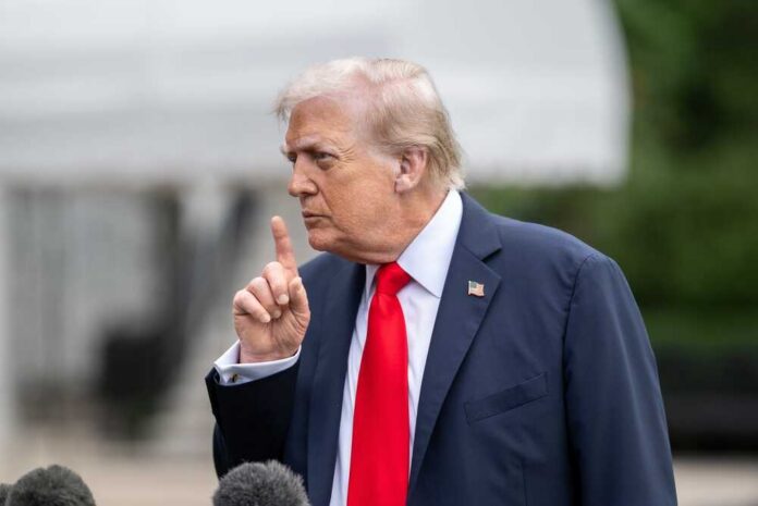 shutterstock_2723709261.jpg A man in a suit gesturing with his finger during a press conference