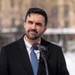 Individual speaking at a podium in a winter outdoor setting