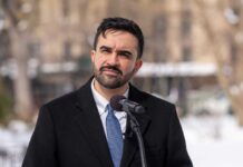 Individual speaking at a podium in a winter outdoor setting