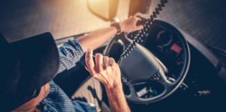 A truck driver using a microphone while driving