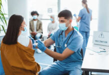 Healthcare worker vaccinating woman in clinic setting