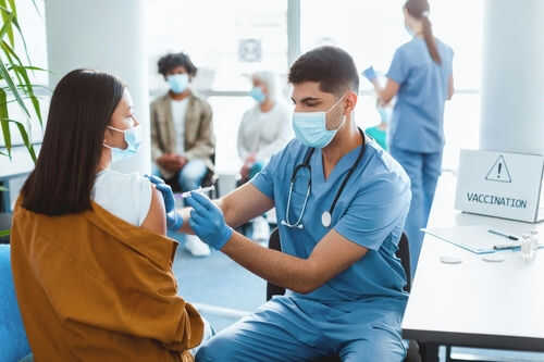vaccination2580294277jpg Healthcare worker vaccinating woman in clinic setting