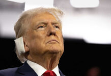 Court DERAILS Trump’s Anti-Woke Agenda Man in suit with red tie and ear bandage looking upward
