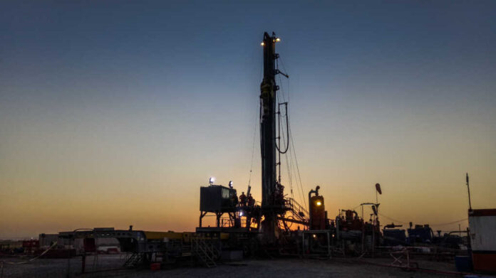 Silhouette,Of,Drilling,Rig,Activity,In,Kurdistan,,Iraq,Region. Drilling rig silhouetted against a sunset with workers visible