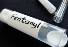 A glass container labeled 'Fentanyl' with a white powder inside