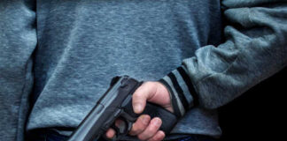 Person holding a handgun behind their back