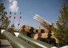 Iran’s Underground Armory Sparks US Panic Military missiles displayed outdoors with Iranian flags in the background