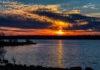A vibrant sunset over a lake with colorful clouds